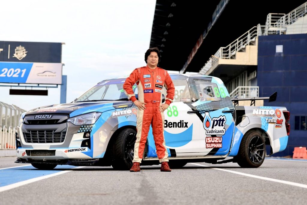 A person standing next to a race car
Description automatically generated